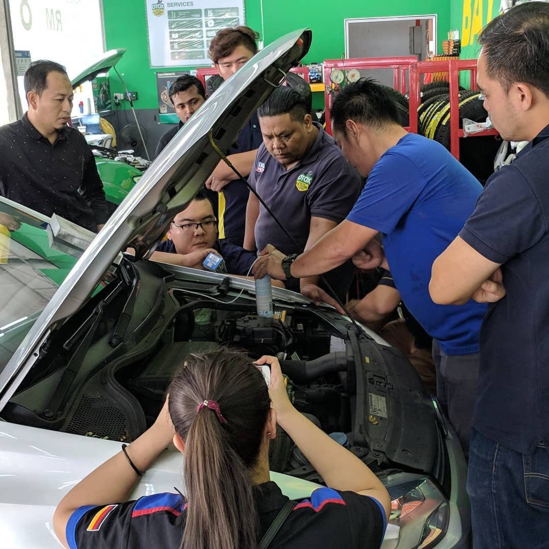 DTOX mechanics working on an engine bay together